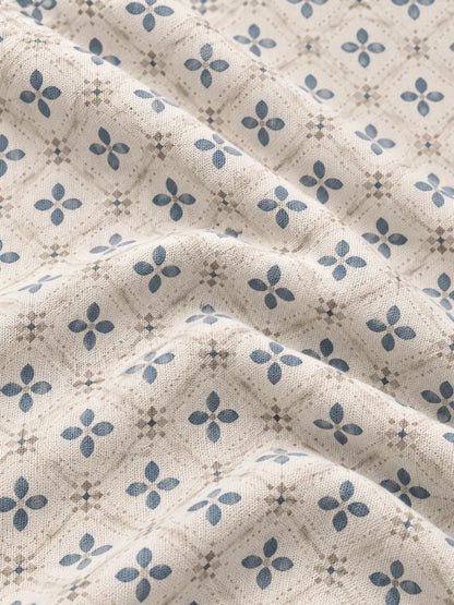 Cremefarbener Golfpullover aus Funktionsmaterial mit blauem Blumenmuster und kurzem Reißverschluss